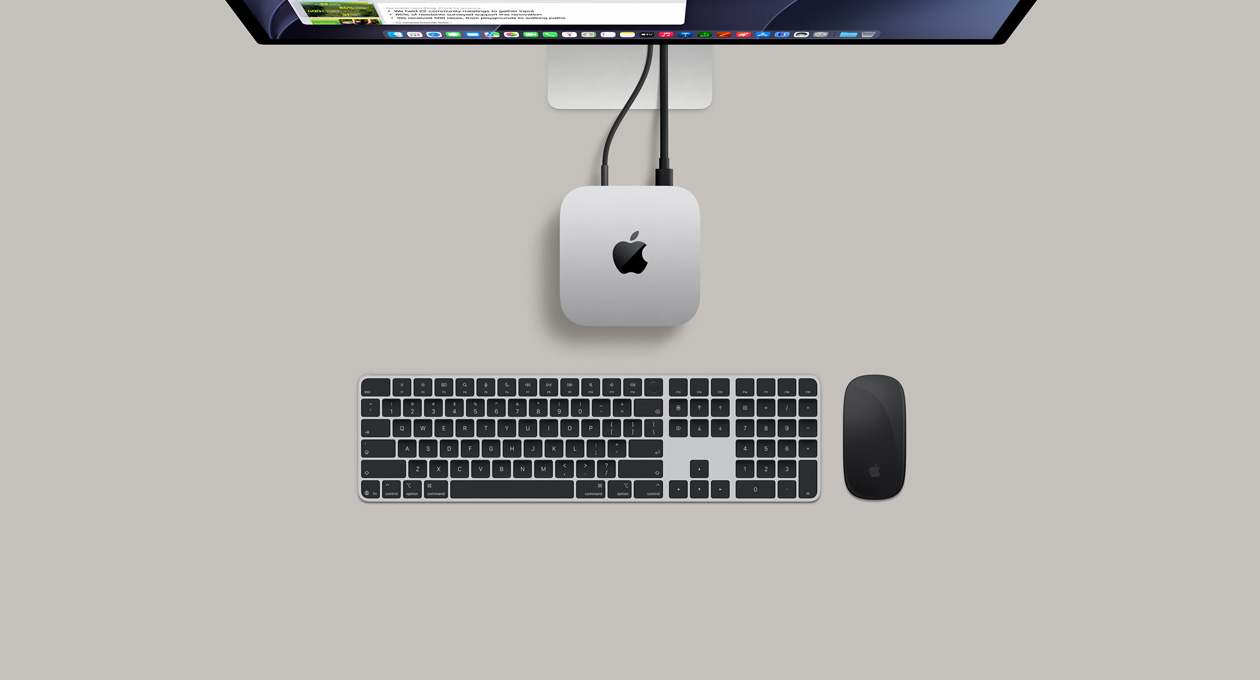 Overhead view of a silver Mac mini connected to a display, beside a keyboard and mouse